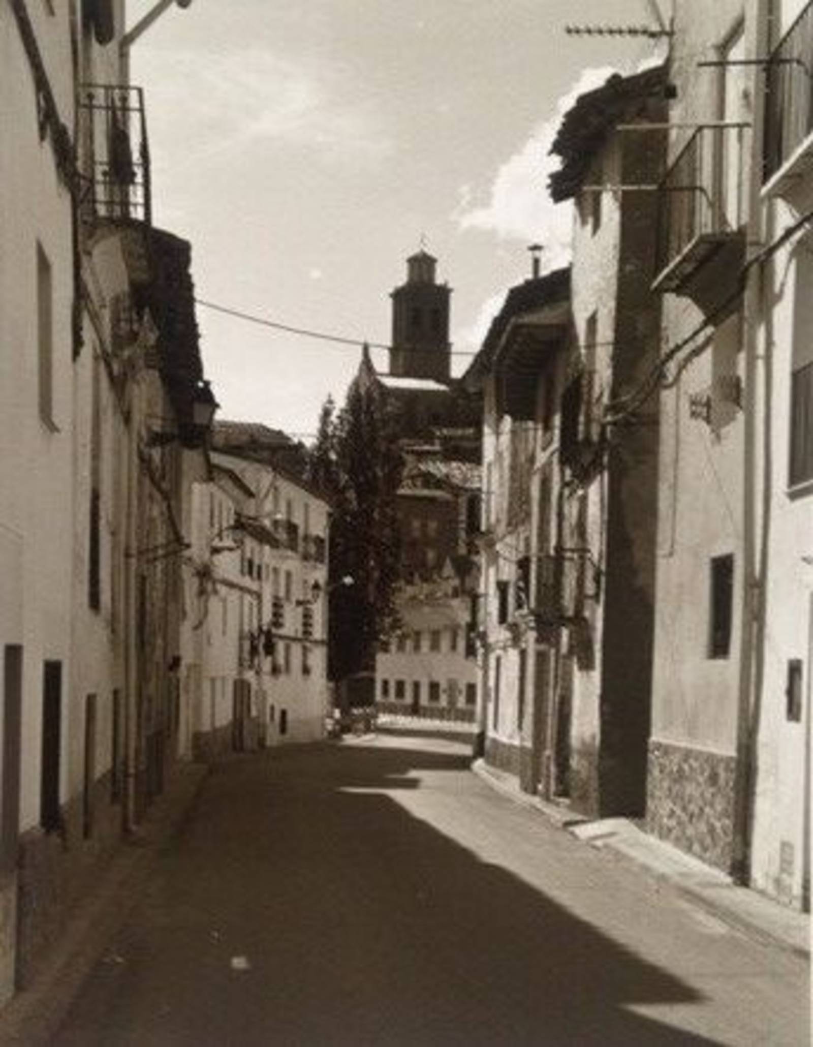 schwarz weiß Bild einer engen Straße durch Häuser