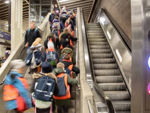 Kinder nehmen die Rolltreppe in einer Stadtbahnstation.
