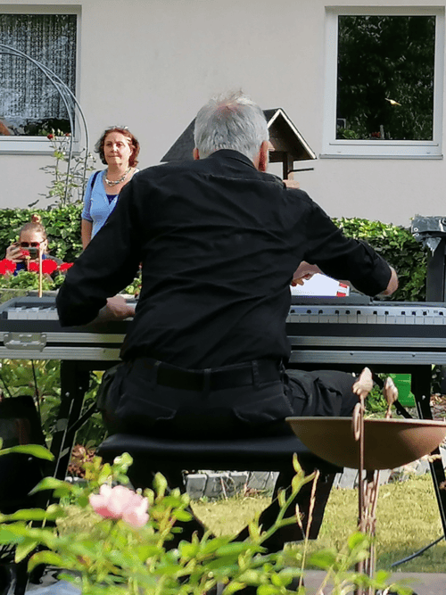 Mann spielt E-Piano im Garten