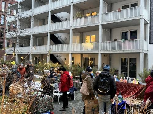 Menschen an weihnachtlichen Ständen in einem Innenhof.