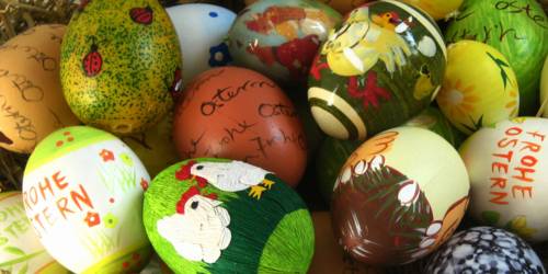 mit Oster- und Frühlingsmotiven und dem Schriftzug "Frohe Ostern" bemalte Eier