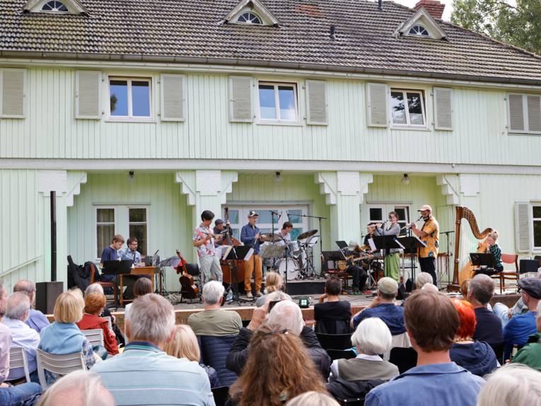 Publikum verfolgt ein Konzert unter freiem Himmel.