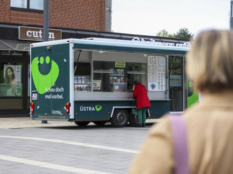 Eine Frau steht an einem Fahrzeug mit der Aufschrift "ÜSTRA Servicemobil".