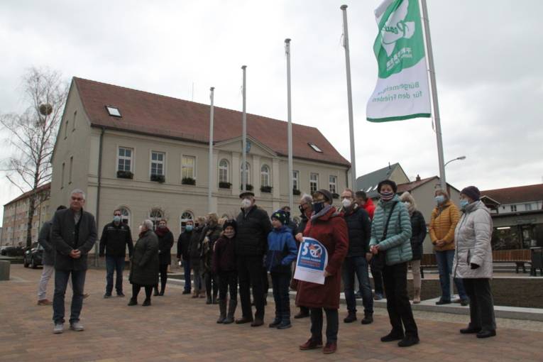 Menschen vor Gebäude mit Flaggen 